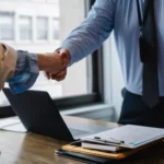 A translator and a client shake hand after successful license translation.