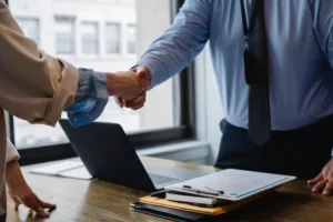 A translator and a client shake hand after successful license translation.